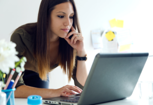 Mujer joven solicitando una tarjeta de crédito Santander a través de la computadora.
