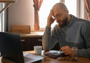 Persona preocupada revisando sus finanzas debido a un alto nivel de deuda que limita nuevas oportunidades.