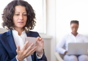 Persona revisando su celular preocupada mientras el banco analiza su comportamiento financiero y perfil crediticio.